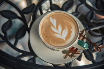 Latte Art on a hot latte in a ceramic cup on a table.