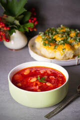 Beetroot soup made with vegetables beans and meat: borsht, bortsch, borshch, borscht. Garlic buns pampushky.