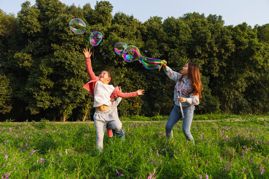 Happy Asian Family Playing In Spring Field