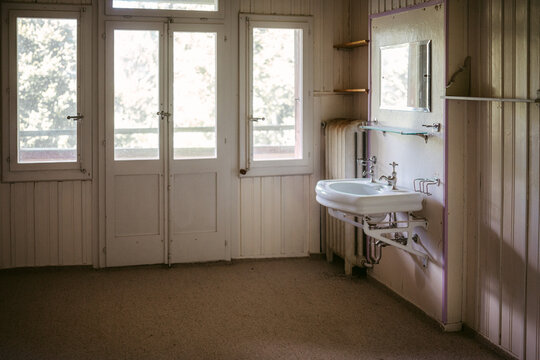 Interior of empty bathroom with wooden walls in abandoned house