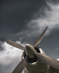 Old propeller airplane, vintage sepia black and white tone, against the sky background. Propeller and turbine detail