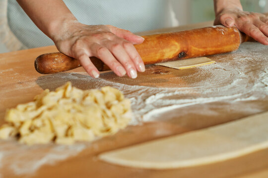 Pasta - spreads pasta dough with a wooden rolling pin