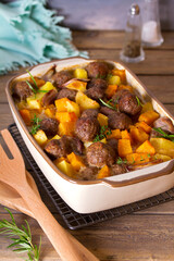 Meatballs with pumpkin, potatoes  and herbs in baking dish