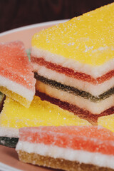 Colorful jelly candy in the plate on wooden background. Multi-colored marmalade jelly candy's. Heap of triangular and rectangular  marmalade candy.
