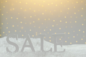Christmas sale word sale on white snow with warm soft light on background