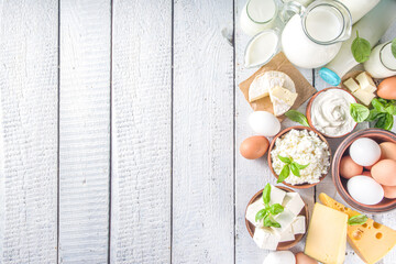 Set of Various Fresh Dairy Products - milk, cottage cheese, cheese, eggs, yogurt, sour cream, butter on wooden background