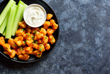 Cauliflower buffalo wings with celery and sauce