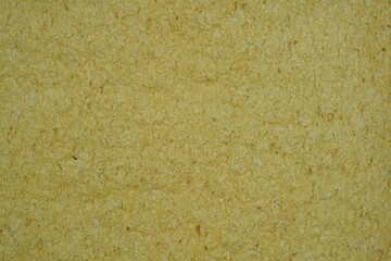 A texture and background of a rough surface of a soft yellow of a sponge.