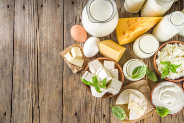 Set of Various Fresh Dairy Products - milk, cottage cheese, cheese, eggs, yogurt, sour cream, butter on wooden background