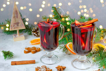 Christmas mulled red wine with spices and oranges on a wooden rustic table.New Year traditional drinks
