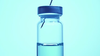 Filling syringe with vaccine from vial, close up. Administrating medication with medical needle syringe and vaccine injection for patient vaccination in medical hospital.  Health and medical concepts.