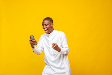 african muslim man feeling happy and excited while looking at his phone