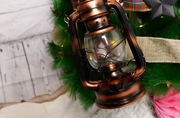 Árbol de navidad con gorro de Papa Noel, farol y elementos de decoración para las fiestas.