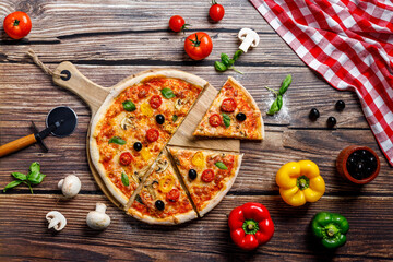Deliciosa pizza italiana en la mesa de madera para la vista superior del restaurante italiano con verduras como pimientos, champiñones, mozzarella, tomate, jamón, aceitunas, aceite y orégano