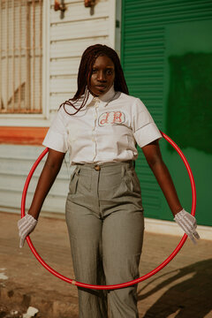 Portrait of a young African American woman with hula hoop.