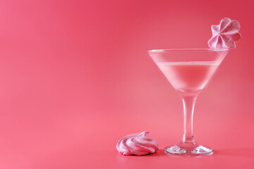 Pink milk cocktail in a glass with merengue cookies