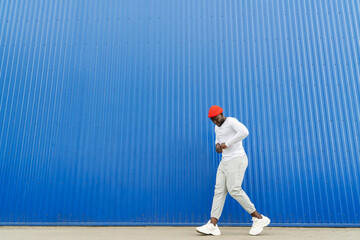 Black Man Dancing on Blue Wall