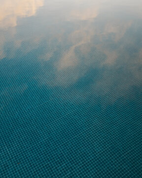 Sky reflection from a swimming pool during sunset on a summer evening.