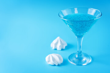Blue milk cocktail in a glass with merengue cookies