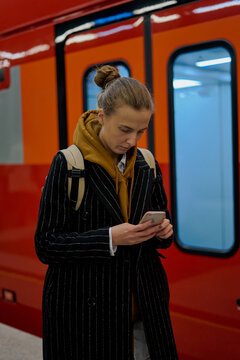 a business woman responds to emails and messages in messengers on her smartphone before taking the train to the airport in moscow russia