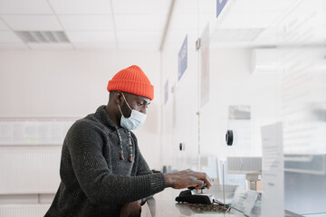 Black Man Wearing Face Mask Using Cellphone To Pay