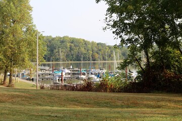 A view of the marina at the lake from the green grass field.