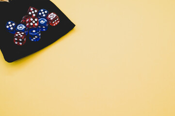 Top view of red and blue dice on dice bag isolated on yellow background