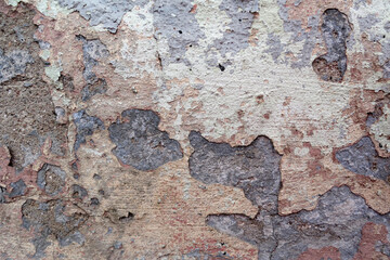 
The wall is covered with many layers of paint and rust, the background looks like unpainted concrete. devastation.