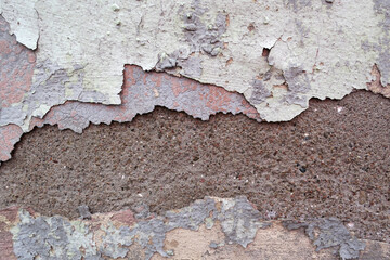 
The wall is covered with many layers of paint and rust, the background looks like unpainted concrete. devastation.