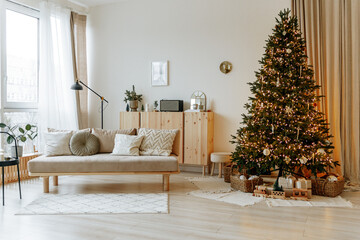 Bright interior of the living room with a sofa and a large Christmas tree. New year's interior. - obrazy, fototapety, plakaty