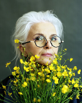 Senior aged woman with buttercups