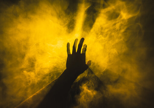 hand touches yellow smoke