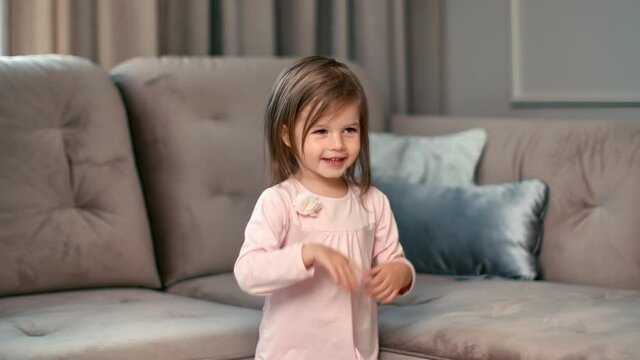 Cute girl dancing clapping hands having positive emotion at home. Shot on RED Raven 4k Cinema Camera