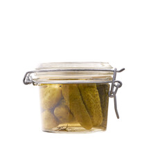Pickled cucumbers in a glass jar isolated on a white background.