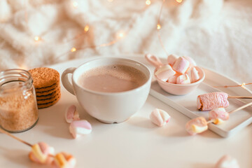 Delicious sweet aromatic cocoa drink or hot chocolate with marshmallow sweets in mug on white table