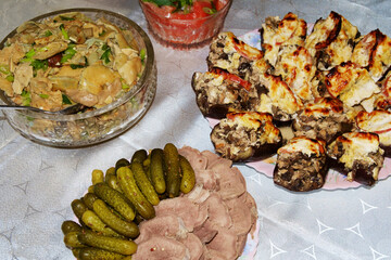 Festive table. Boiled pork tongue with pickles and spices, salted mushrooms seasoned with herbs, stuffed eggplant.