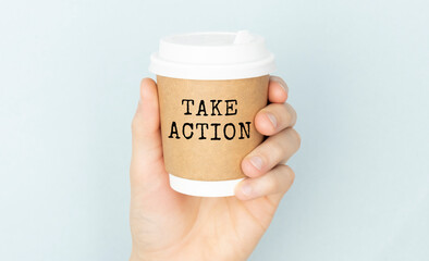 Take Action text on a jar with coffee in hand on a white background.