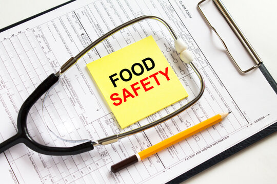 Text Food Safety on a yellow sticker with a stethoscope lying on a folder with medical documents
