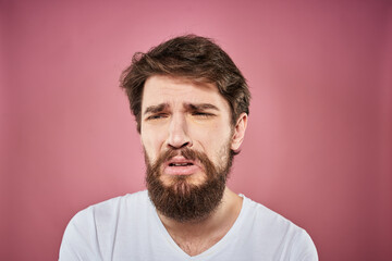 Fototapeta premium bearded man in white t-shirt emotions displeased facial expression studio pink background