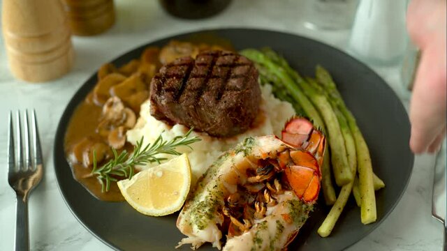 surf and turf, lobster tail and tenderlon steak with mushroom gravy sauce
