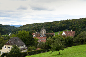 Fototapeta na wymiar Beautiful view of the village of Bebenhausen with its abbey and historical half-timbered houses. The village is surrounded by colorful forest and fresh green meadows.