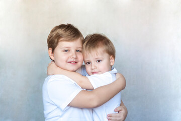 Boys-brothers in an embrace. Happy boys hug each other. Overjoyed, the best friends embrace.