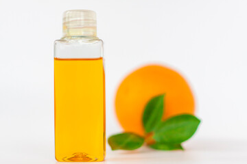 Orange oil for the body. Orange on a white background. Organic SPA cosmetics with herbal ingredients.