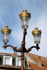 Fototapeta na wymiar Ville de Saint-Avold, candélabre à 3 branches ou réverbère rétro en centre ville, département de Moselle, France