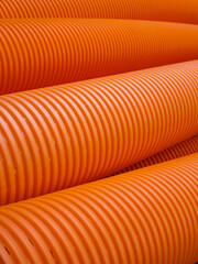 Orange perforated drainage pipe, corrugated. Orange background