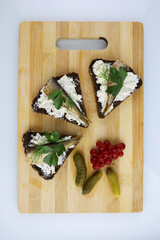 sandwiches with sprats and viburnum berries on a wooden Board