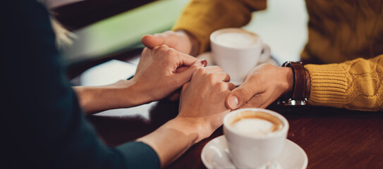 romantic couple holding hands at coffee shop