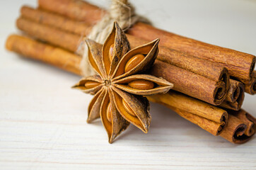 Cinnamon sticks and star anise on a light wooden background.