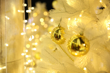 Blurred Christmas background with bokeh, Golden balls on a white Christmas tree