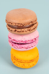 Cake macaron or macaroon on turquoise background from above, colorful almond cookies, pastel colors, vintage card